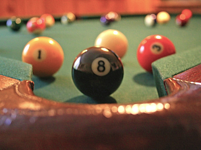 Selection of pool cues laid out on green baize