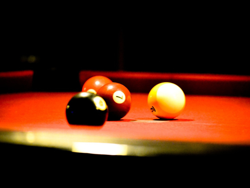 American pool balls on a red table